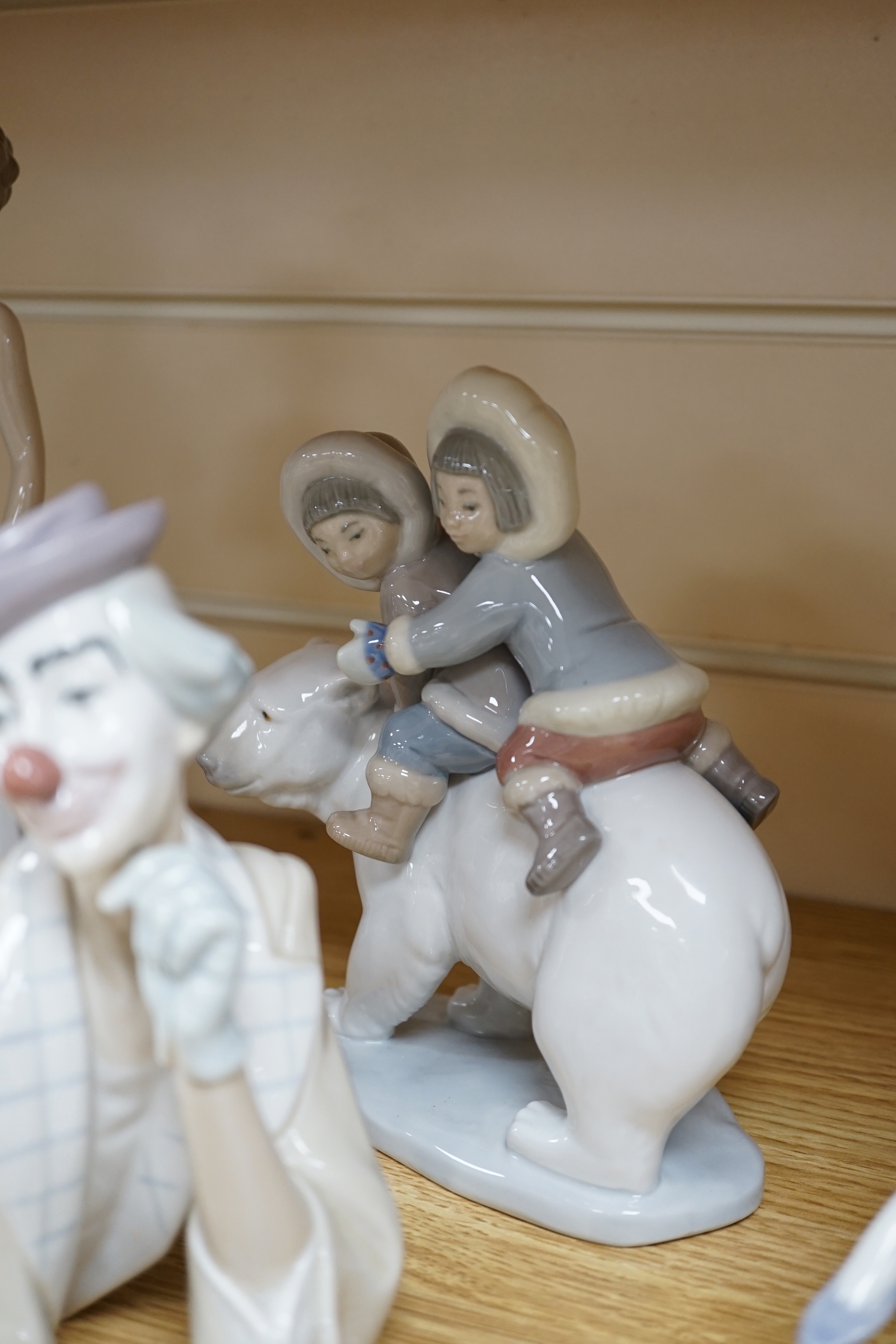 Seven Lladro figures including a clown together with three Lladro bells, the clown 37cm wide